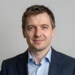 Портрет уверенного российского бизнесмена на нейтральном фоне для сайта по электрике автомобилей Mitsubishi